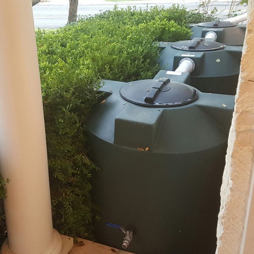 Green Water Harvesting Tanks Hiding in Bushes