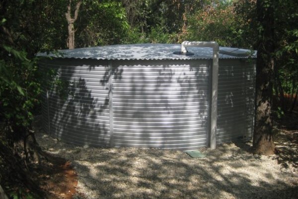 Large Metal Water Tank Amongst the Shade of Trees